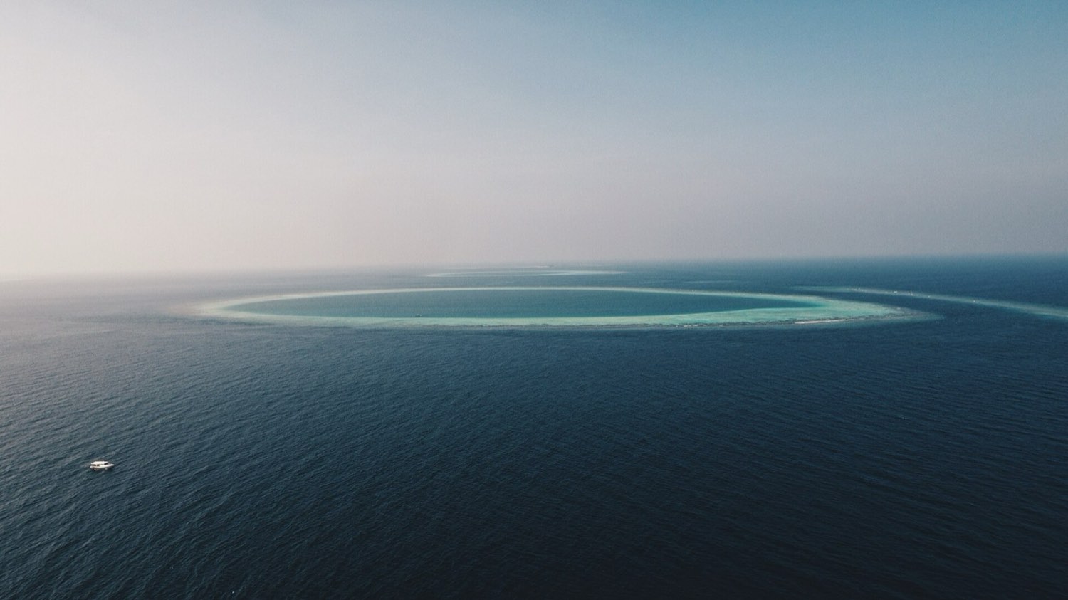 Aerial view of a Maldivian atoll and its turquoise lagoon